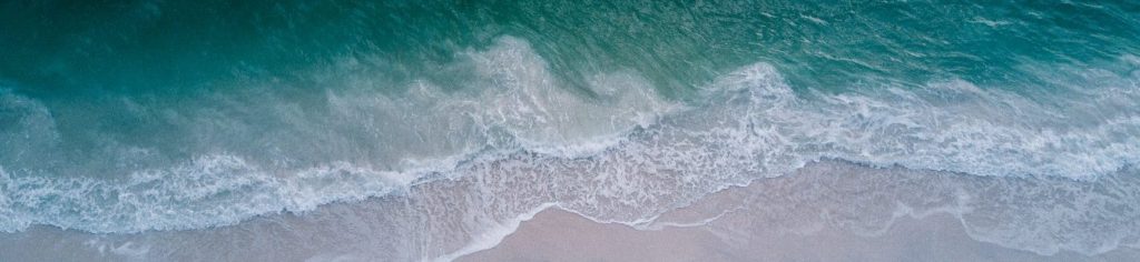 body of water beside beach sand